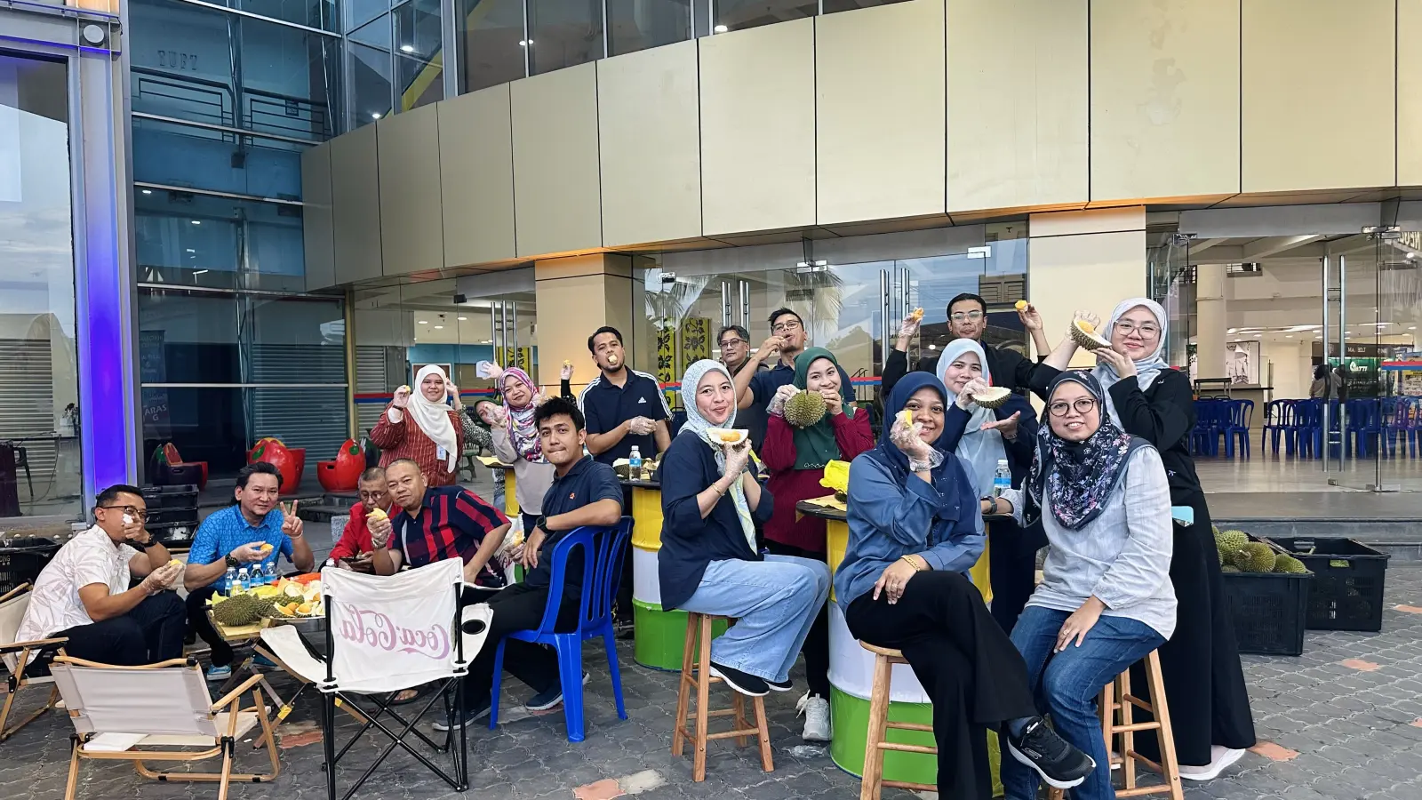 Sekumpulan rakan sekerja di bufet durian Durian Khakha di luar gerai Melaka Mall, membelah dan makan durian segar